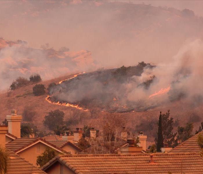 Wildfire flames on hillside brush headed towards homes in Orange County Canyon fire