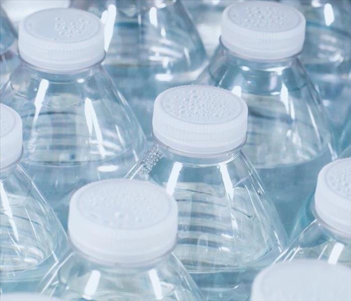 A close up of a well stocked supply of lots of clear plastic drinking water bottles